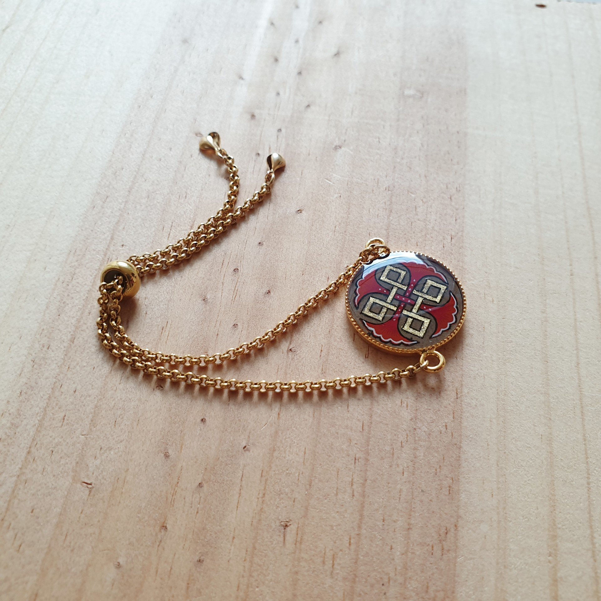 Bracelet r&eacute;glable entrelacs or et palmettes rouges ou bleues