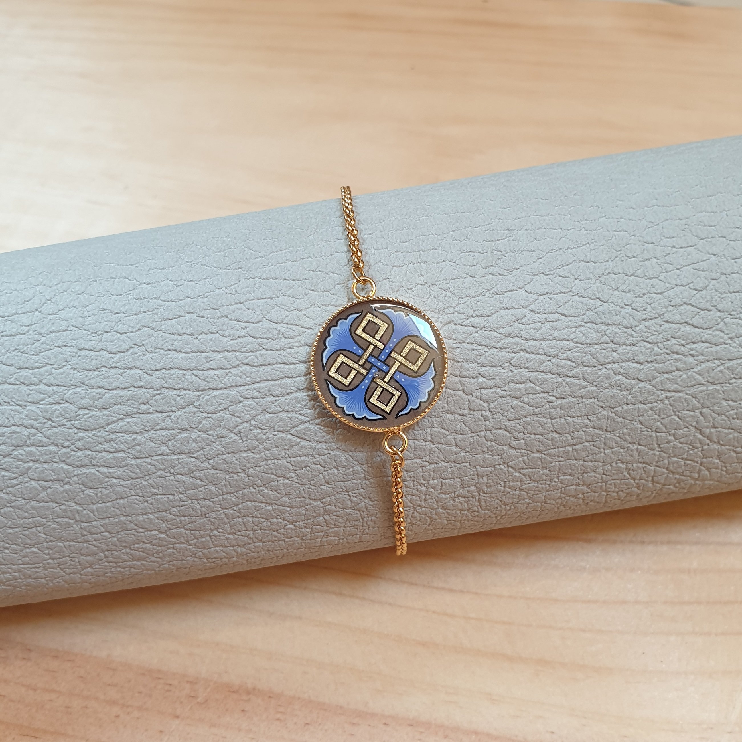 Bracelet r&eacute;glable entrelacs or et palmettes rouges ou bleues