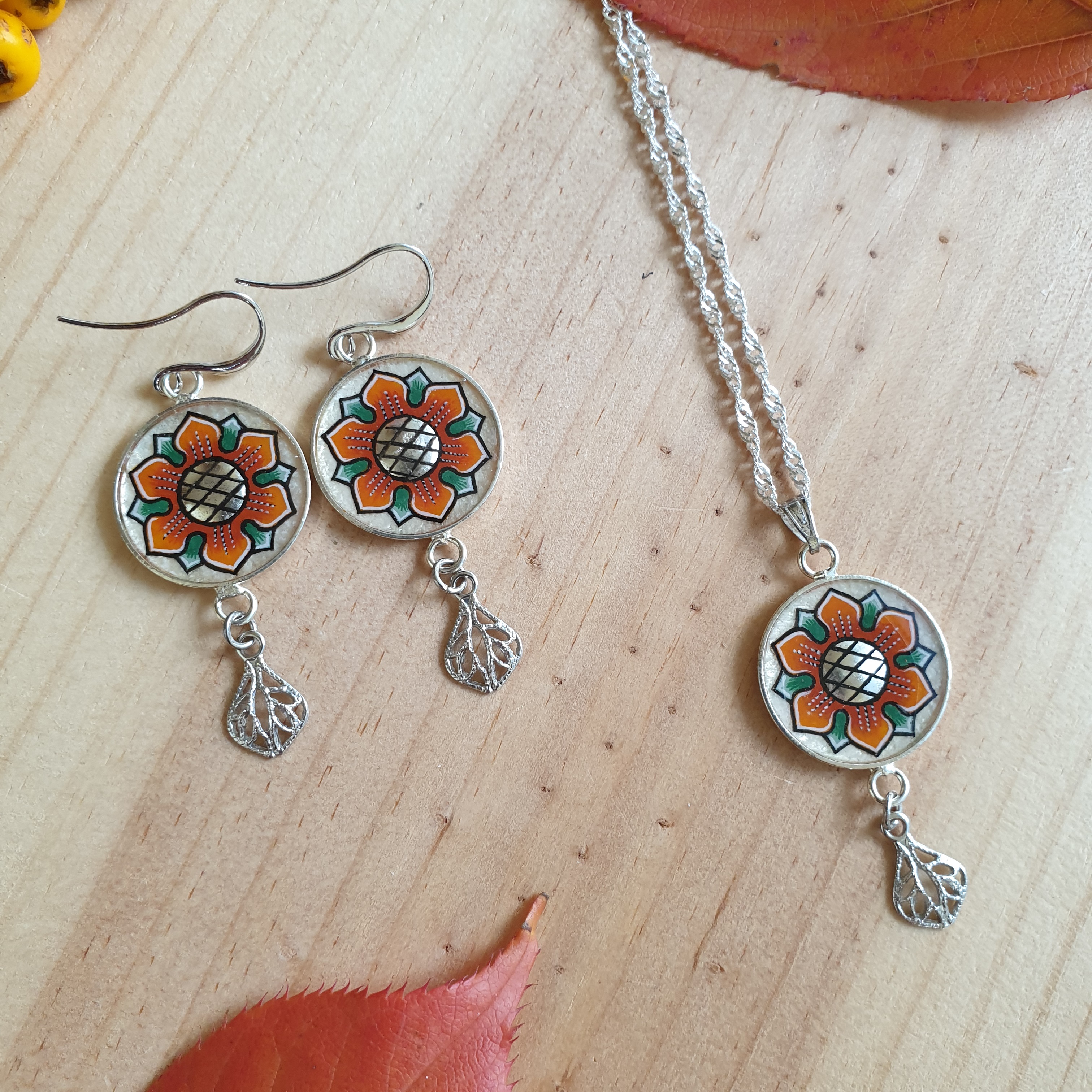Colar com pingente de flores laranja/ouro sobre corrente de prata