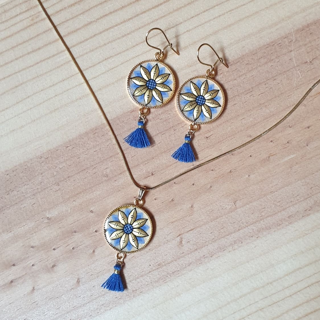 Colar pendente ouro/azul de flores sobre corrente de ouro