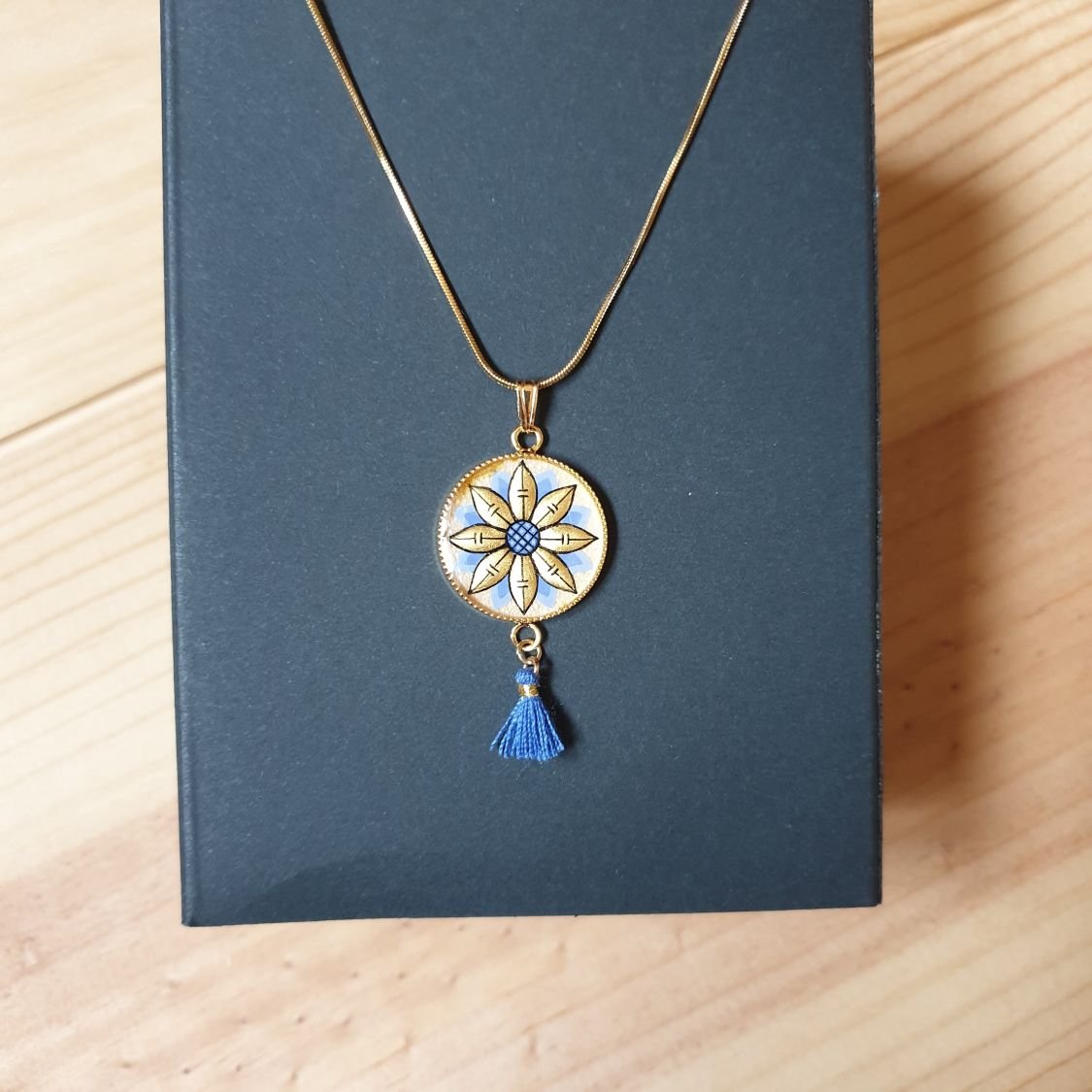 Colar pendente ouro/azul de flores sobre corrente de ouro