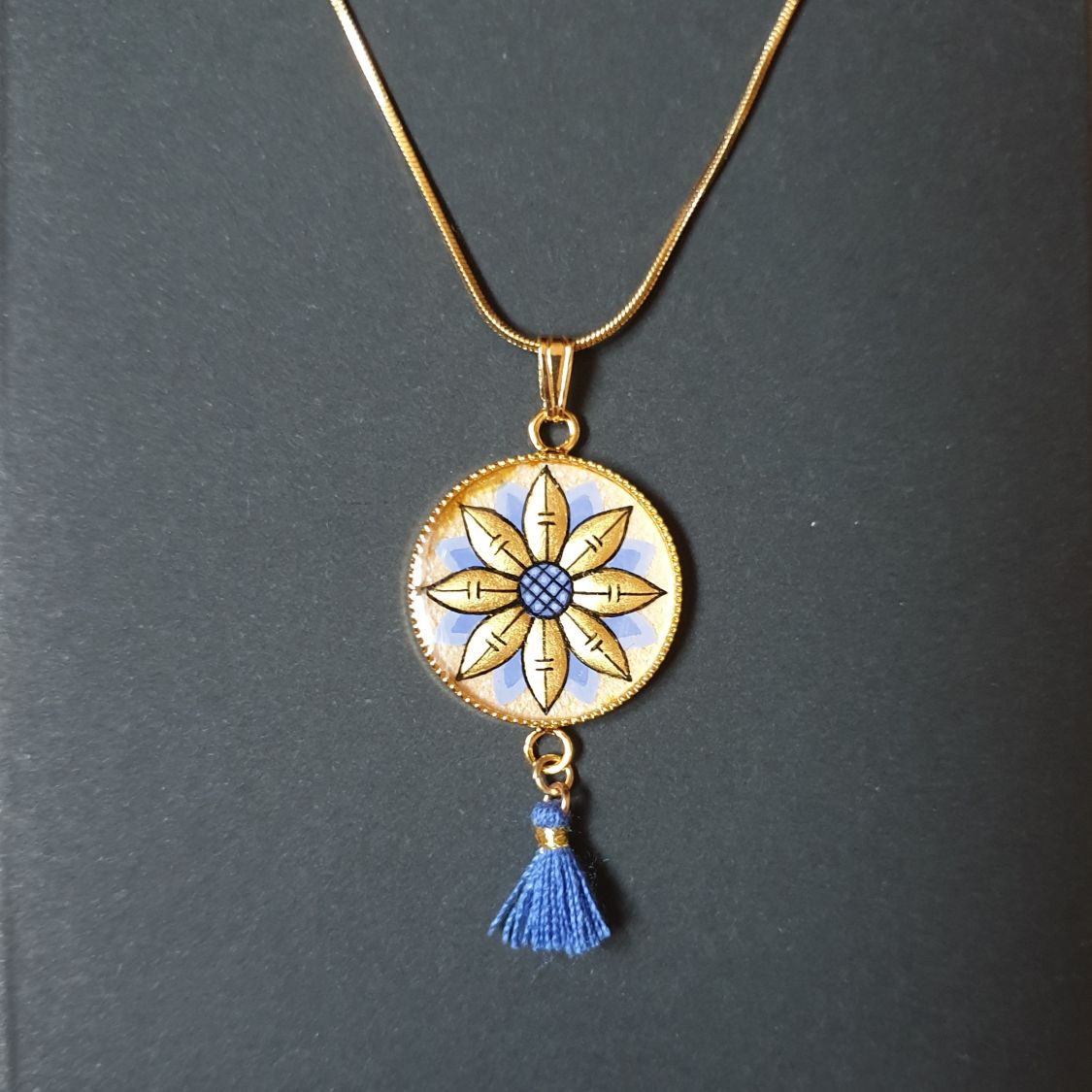 Colar pendente ouro/azul de flores sobre corrente de ouro