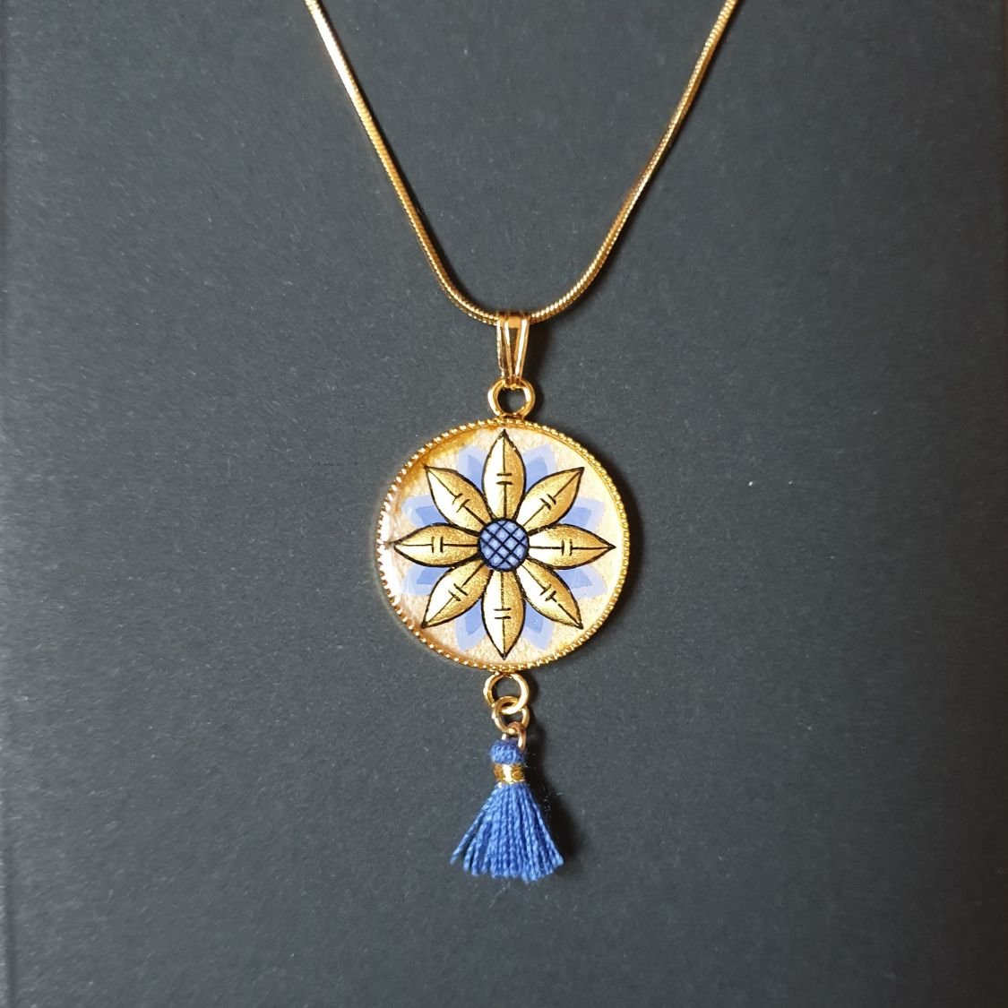 Colar pendente ouro/azul de flores sobre corrente de ouro