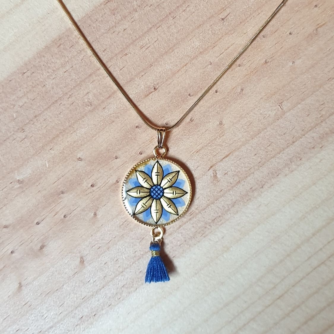 Colar pendente ouro/azul de flores sobre corrente de ouro