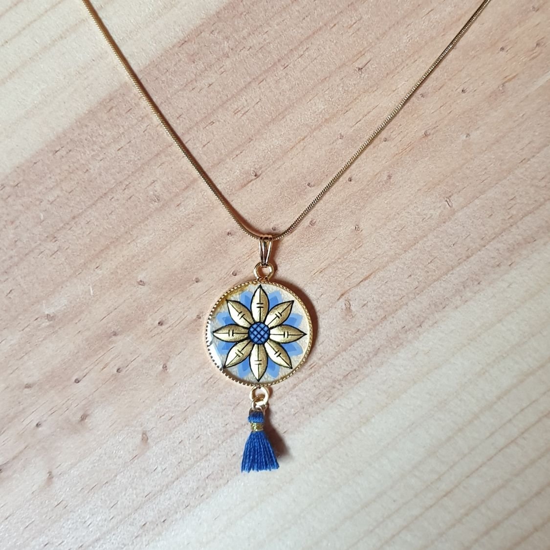 Colar pendente ouro/azul de flores sobre corrente de ouro