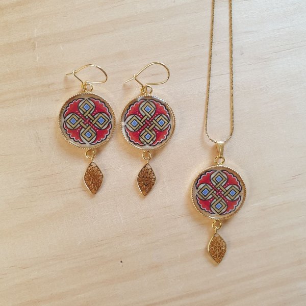 Colar pendente iluminado com palmetas azuis, entrela&ccedil;ado dourado e vermelho sobre corrente dourada