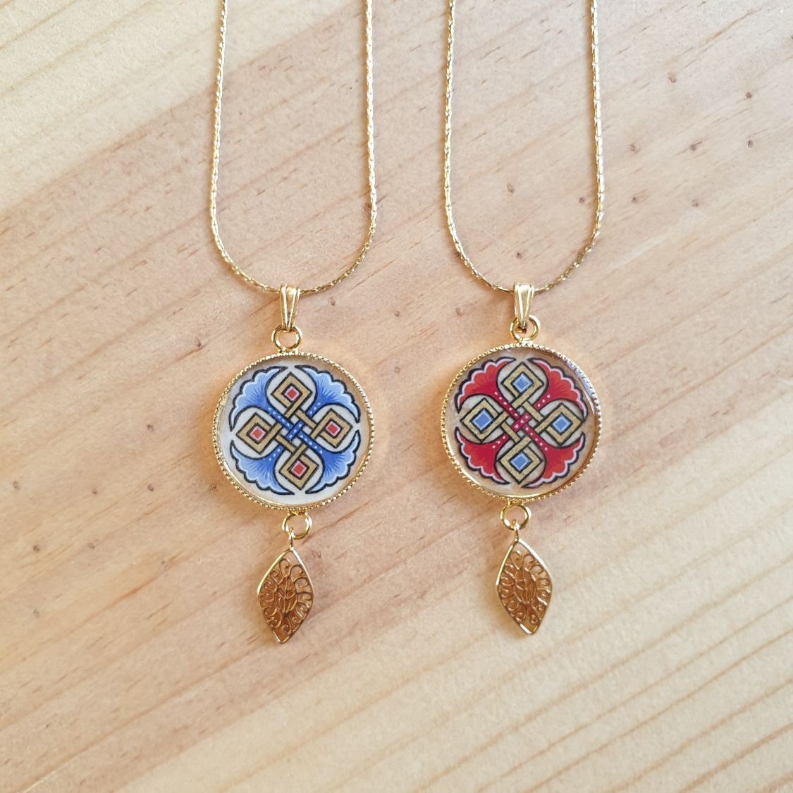 Colar pendente iluminado com palmetas azuis, entrelaçado dourado e vermelho sobre corrente dourada