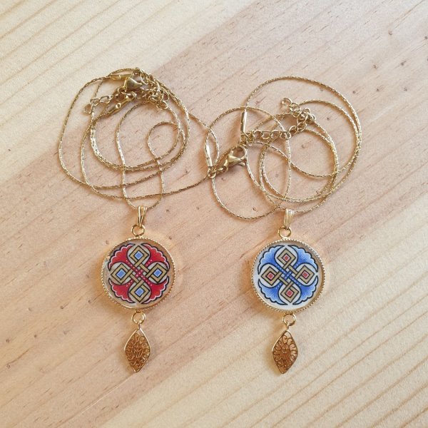 Colar pendente iluminado com palmetas azuis, entrela&ccedil;ado dourado e vermelho sobre corrente dourada