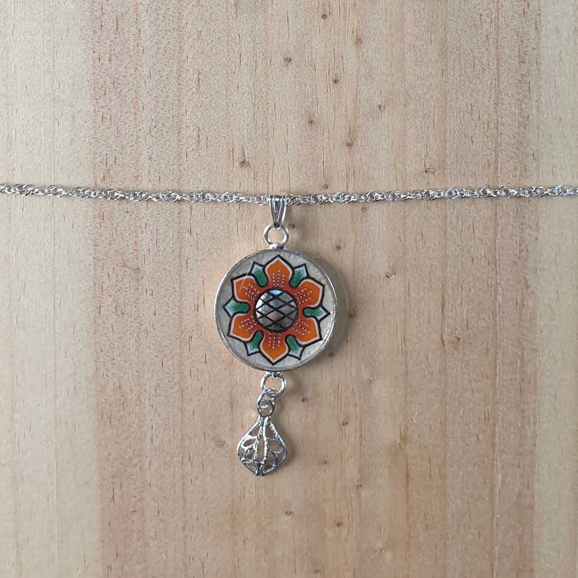 Colar com pingente de flores laranja/ouro sobre corrente de prata
