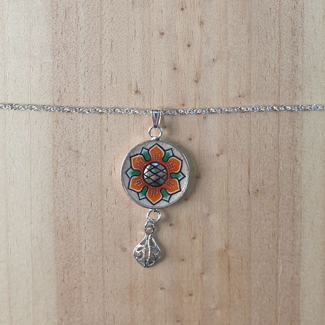 Colar com pingente de flores laranja/ouro sobre corrente de prata