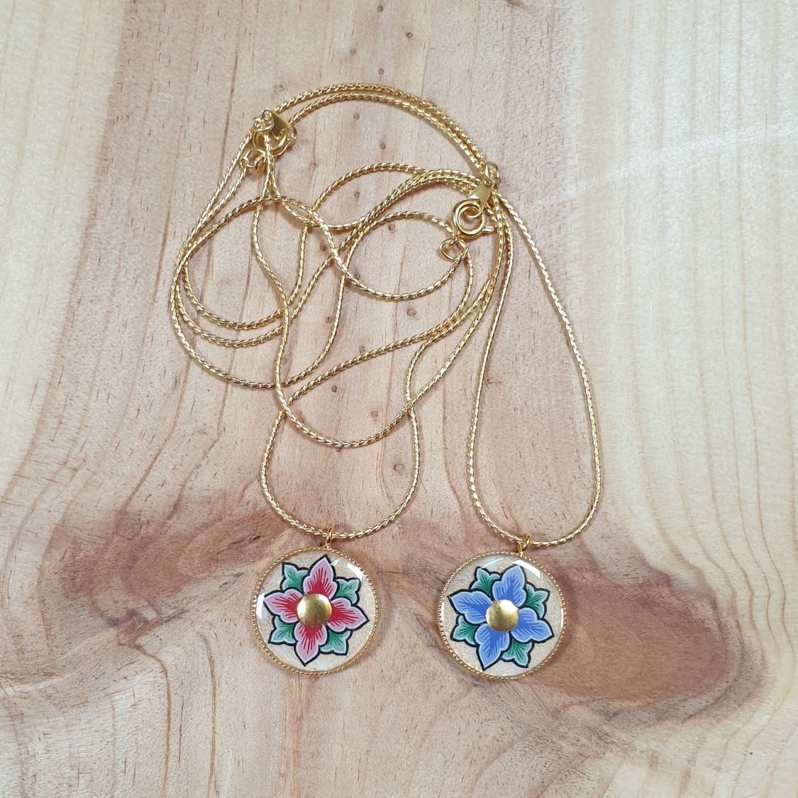 Colar com flores rosa ou azul sobre corrente dourada