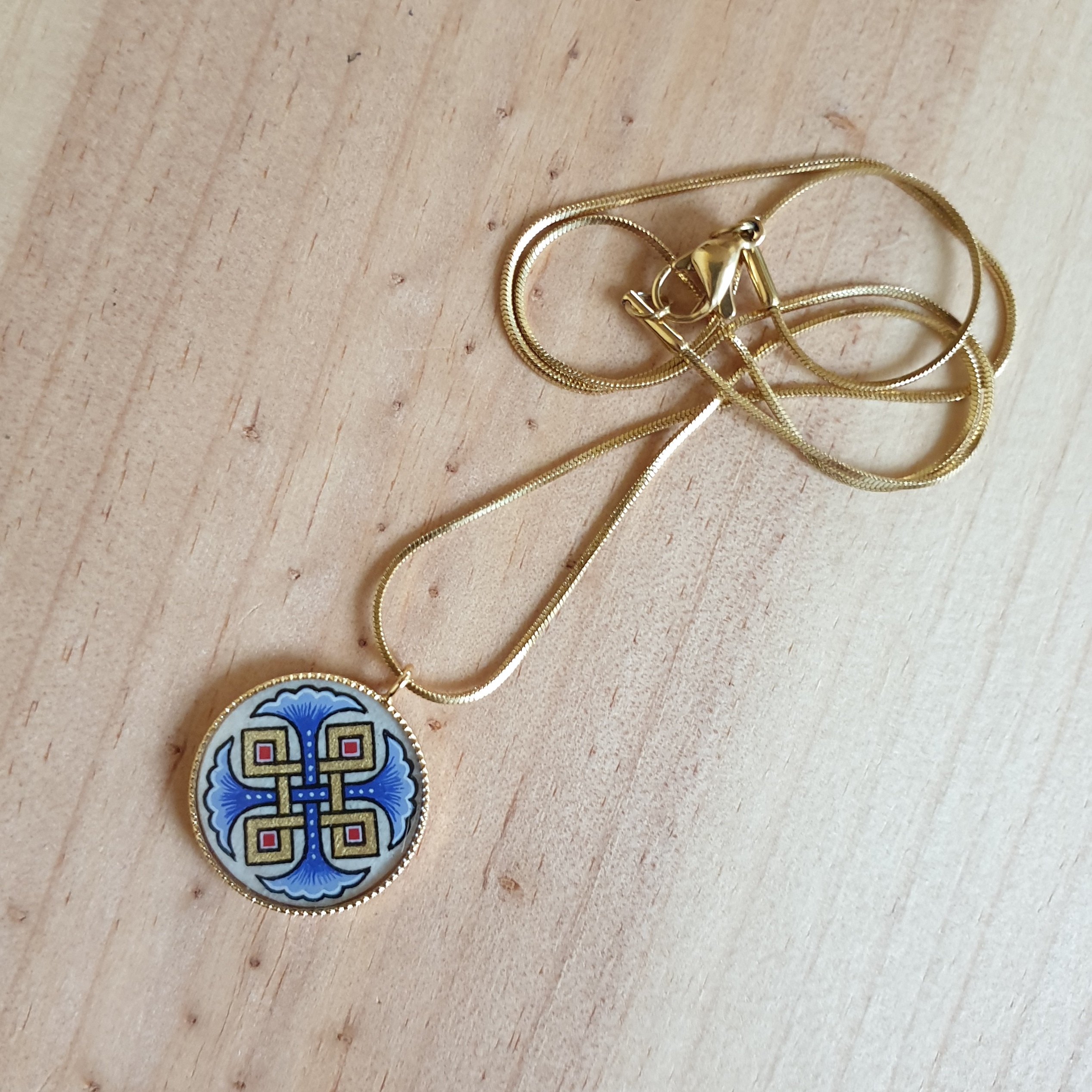 Colar pendente com palmetas azuis, entrelaçamento dourado e vermelho sobre corrente dourada