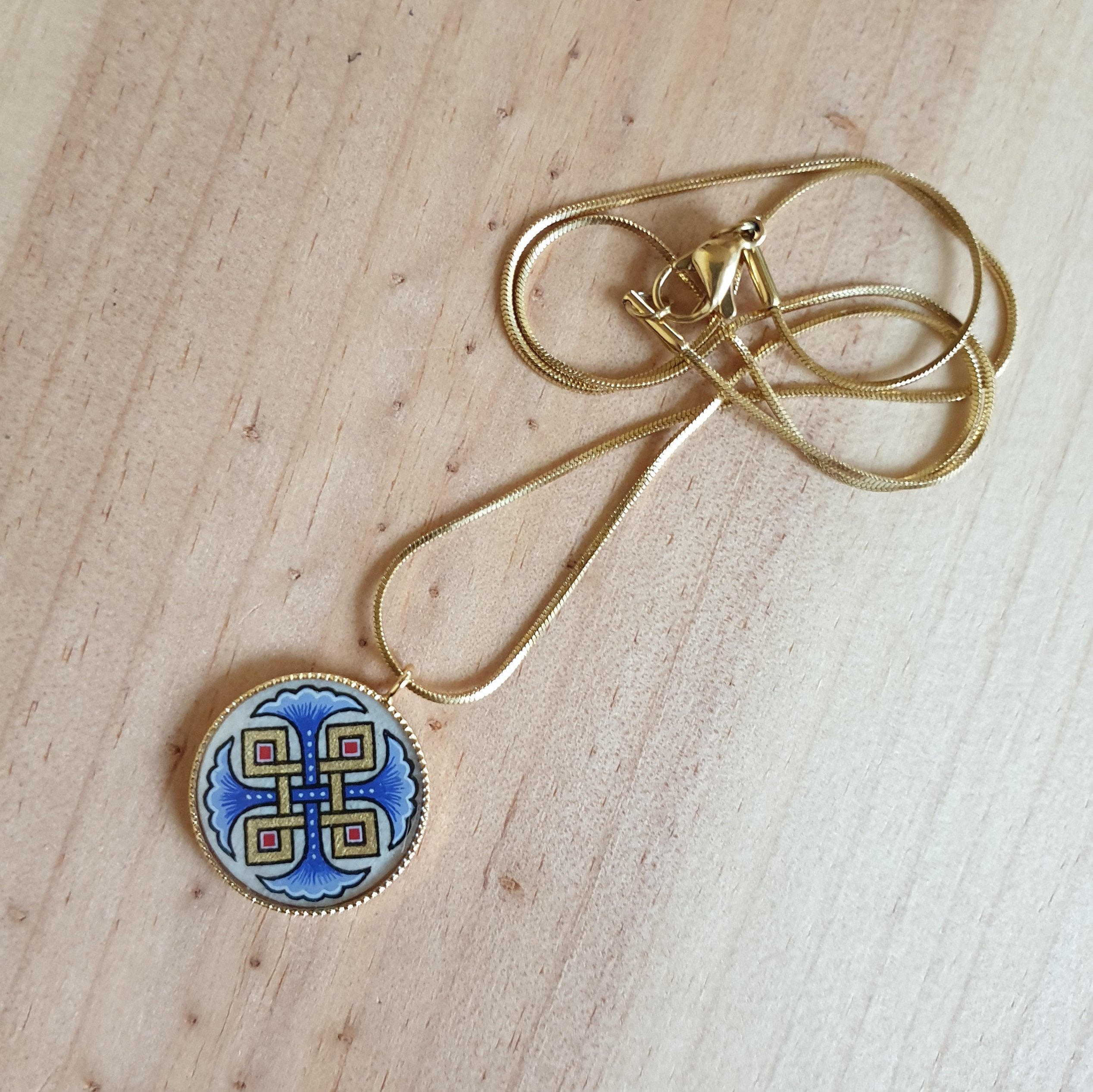 Colar pendente com palmetas azuis, entrelaçamento dourado e vermelho sobre corrente dourada
