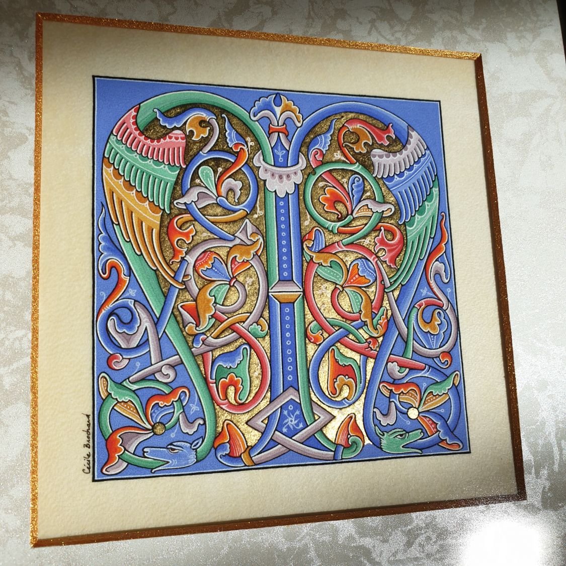 Letra românica iluminada M emoldurada