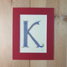 Letra K iluminada com entrelaçamento